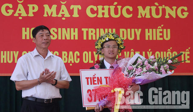 Bí thư Tỉnh ủy Bắc Giang Bùi Văn Hải chúc mừng và khen thưởng em Trịnh Duy Hiếu. (Ảnh: Báo Bắc Giang)