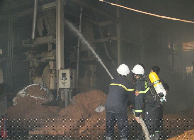 Cảnh sát PCCC vào bên trong kho chứa gỗ phun nước không cho ngọn lửa cháy lan.