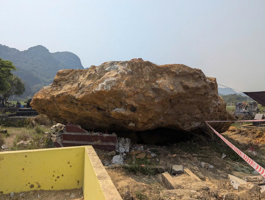 Tảng đá có kích thước lớn rơi từ đỉnh núi xuống, đè nát nhiều ngôi mộ, gây cảnh tượng tan hoang.