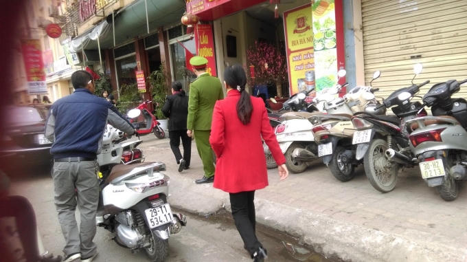 Có mặt lực lượng công an phường tại đây, nhưng chủ bãi xe vẫn ngang nhiên "dẫn" khách vào gửi xe nhằm kiếm lời. (Ảnh Thu Hường)