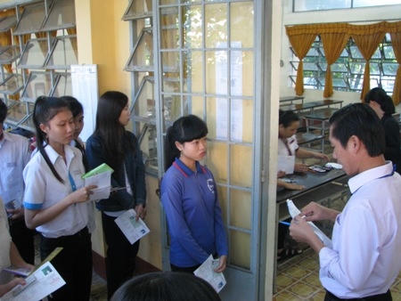 Giám thị gọi thí sinh vào phòng thi và kiểm tra rất kỹ giấy tờ của các em. (Ảnh: Huỳnh Hải)
