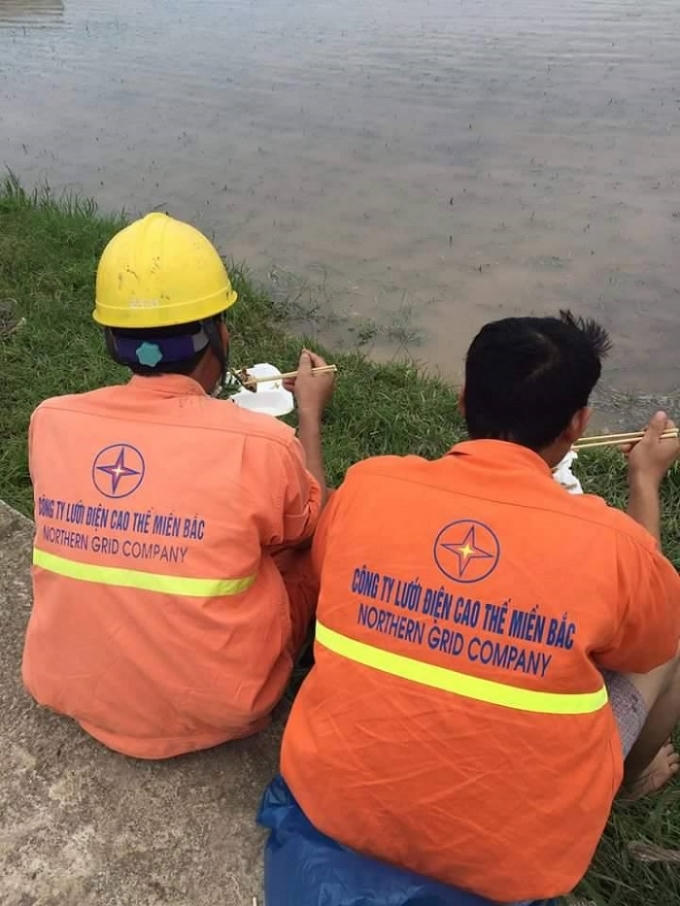Công nhân điện lực tranh thủ ăn trưa để kịp tiến độ khắc phục lưới điện bị hư hỏng tại Thái Bình.   Ảnh: Internet.