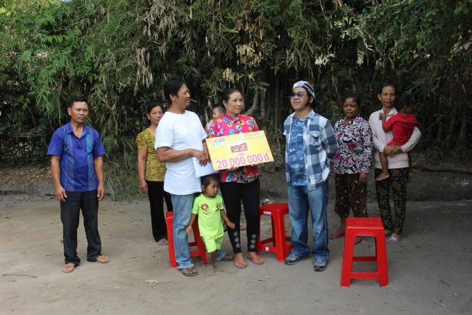 Nghệ sĩ Bạch Long trao phần thưởng cho chị Hồng.