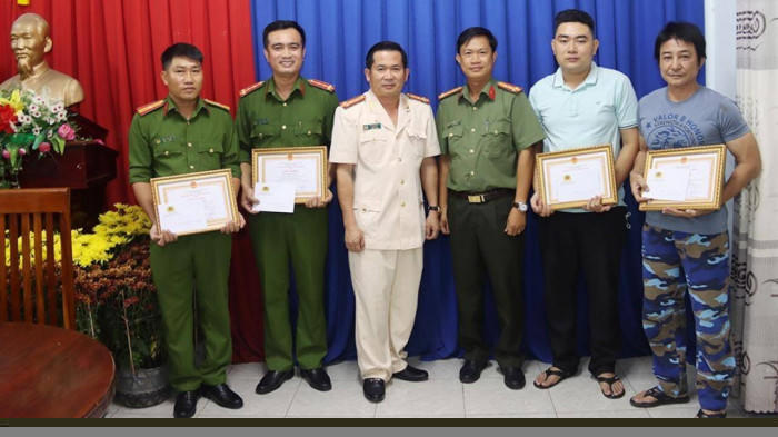 Đại tá Đinh Văn Nơi, Giám đốc Công an tỉnh An Giang tặng giấy khen đột xuất và thưởng nóng cho 2 cán bộ cùng 2 người dân tham gia bắt cướp.