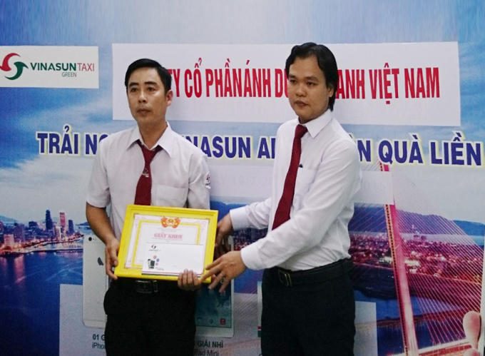 Tài xế Thêm (trái) nhận khen thưởng nóng từ ông Trần Thanh Tâm, Giám Đốc Vinasun Green Đà Nẵng.