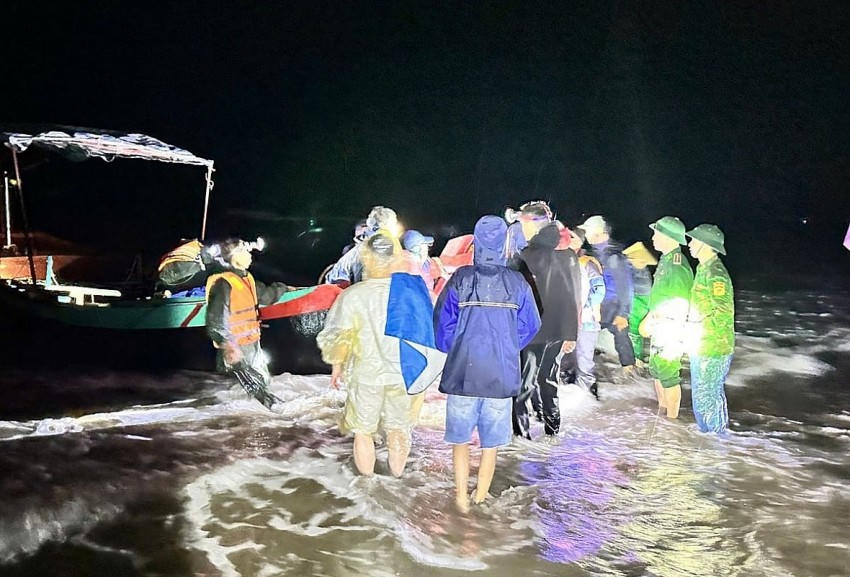 Bộ đội Biên phòng và chính quyền địa phương hỗ trợ ngư dân kéo vào bờ neo đậu an toàn các thuyền đánh cá bị lật. Ảnh: BĐBP cung cấp.