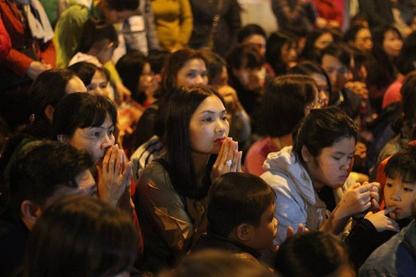 Người dân ngồi hành lễ dưới lòng đường Tây Sơn lúc này đã cấm xe cộ đi qua.