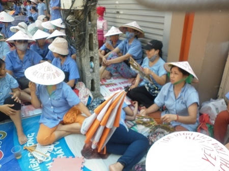 Những người công nhân tại Công ty Dệt nằm  vạ vật trên vỉa hè đòi tiền hỗ trợ. Ảnh: Như Trường