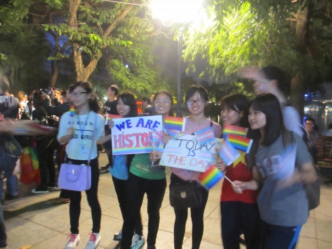 Các bạn trẻ đeo băng rôn khẩu hiệu chúc mừng người chuyển giới, hô vang khẩu hiệu "cảm ơn Quốc hội" tại Hồ Gươm.