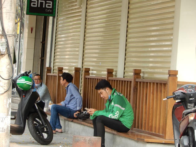 Ba thanh niên tranh thủ nghỉ ngơi, ăn ổ bánh mì lót dạ nhưng vẫn giữ khoảng cách an toàn