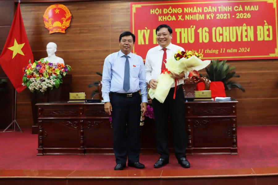 Ông Nguyễn Tiến Hải - Ủy viên BCH TW Đảng, Bí thư Tỉnh ủy, Chủ tịch HĐND tỉnh Cà Mau tặng hoa chúc mừng Tân Chủ tịch UBND tỉnh Cà Mau Phạm Thành Ngại.