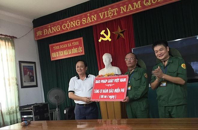 Phó Tổng Biên tập Thường trực Đặng Ngọc Luyến (trái) trao quà cho Ban quản lý Khu di tích Ngã ba Đồng Lộc.