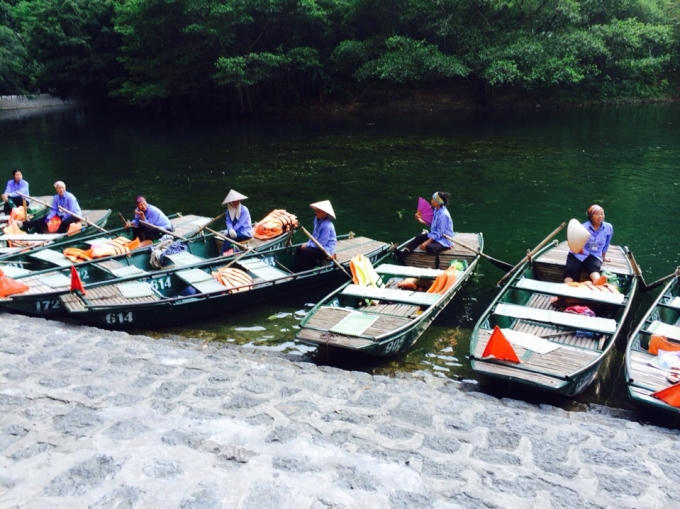 Những chiếc thuyền được sơn màu xanh đang xếp hàng ngay ngắn dọc bên bờ.