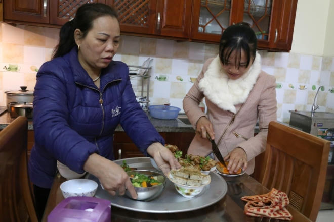 Bà Tuyết cùng con gái sắp xếp mâm cơm, canh để cúng.