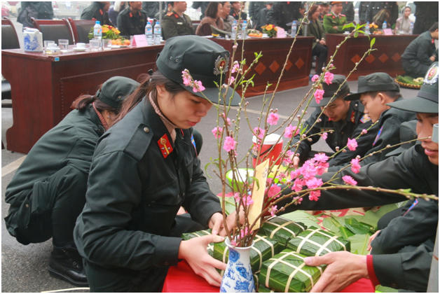 Nữ cảnh sát cơ động khéo léo hoàn thiện chiếc bánh chưng.