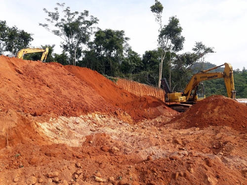Hai chiếc máy xúc tiến hành việc san gạt đất.