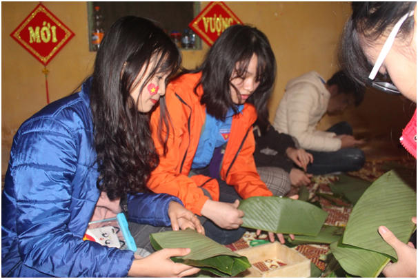Các bạn TNV tập gấp lá rong để cho vào khuôn gói.