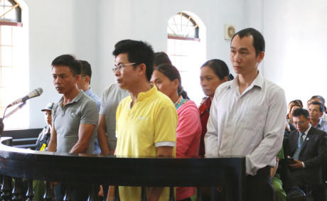 Bị cáo Lợi (áo vàng) cùng các bị cáo khác tại phiên xét xử. (Ảnh: báo Công an nhân dân)