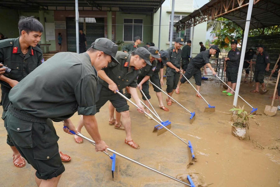 Các chiến sĩ Công an hỗ trợ nhân dân Khánh Hòa dọn dẹp vệ sinh sau đợt mưa lũ.