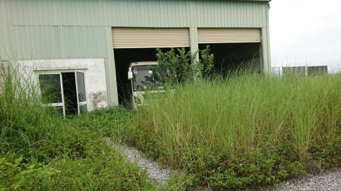 Xe chở công nhân nằm "chết" trong gara, bên ngoài cỏ phủ kín lối vào              Xe tải nhỏ hoen gỉ nằm im giống như số phận của nhà máy