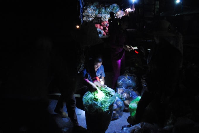 Mọi mua bán, trao đổi rau, củ tại chợ đêm Quỳnh Văn chủ yếu dùng bằng đèn pin. Ảnh Duy Ngợi