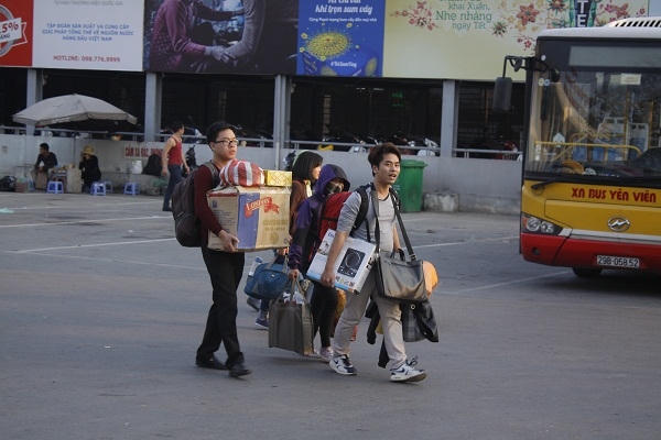 Hàng trăm người “tay xách, nách mang”  tìm những chuyến xe để đi về nơi làm việc.