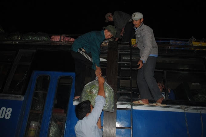 Vận chuyển rau lên xe khách mang đi tiêu thụ. Ảnh Duy Ngợi