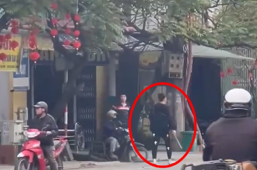 Người đàn ông cầm theo hung khí trên phố. Ảnh cắt từ clip.