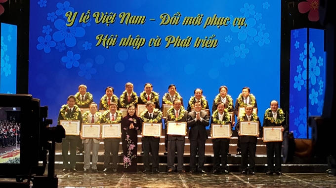 Chủ tịch nước Trương Tấn Sang và Bộ trưởng Nguyễn Thị Kim Tiến trao tặng Bằng khen cho các đơn vị xuất sắc. (Ảnh: Thu Hường)