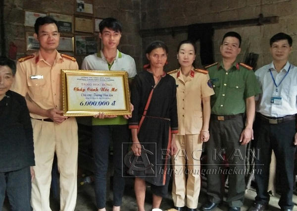 Đại diện lãnh đạo phòng CSGT và Công an huyện Pác Nặm trao quà cho em Trương Văn Lên (Ảnh: Conganbackan.vn).