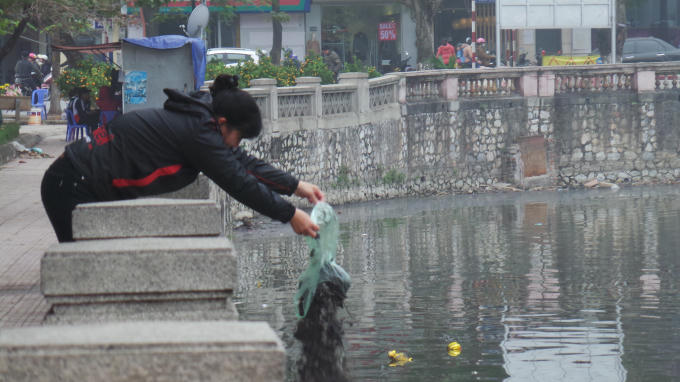Bên cạnh việc thả cá chép thì trưa nay người dân còn thả tàn tro, bát hương…