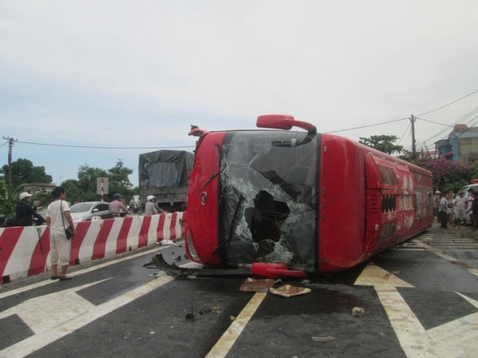 Chiếc xe khách bị vỡ kính, lật ngang trên quốc lộ khiến giao thông bị gián đoạn.