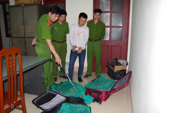 Đối tượng Trịnh Văn Nghị (áo trắng) cùng tang vật tại cơ quan công an.
