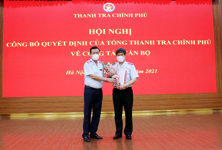 Tổng Thanh tra Chính phủ Đoàn Hồng Phong trao quyết định và tặng hoa chúc mừng tân Vụ trưởng Vụ Tổ chức cán bộ Nguyễn Hữu Hòa. Ảnh: PH