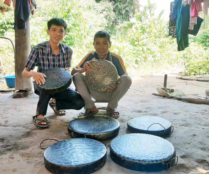 Tác giả (trái) và già làng Pang Ting Ha Thét bên bộ cồng chiêng 6 chiếc.