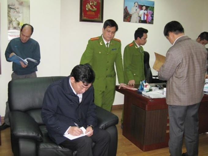 Lâm Phúc Hùng (áo đen) khi bị cơ quan chức năng khám xét nơi làm việc (Ảnh: Tiền Phong)