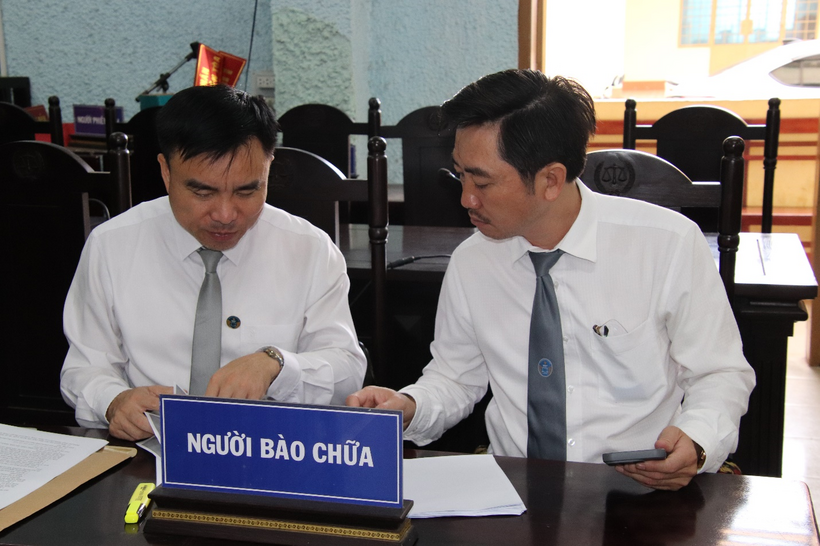 Luật sư Ngô Thanh Quảng và luật sư Đào Thanh Tuấn bào chữa cho các bị cáo trao đổi nghiệp vụ trước giờ phiên tòa xét xử .