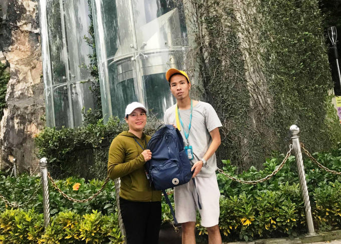 Chị Vân (phải) trả ba lô và tài sản lại cho khách du lịch bị thất lạc đồ. Ảnh: Ngọc Nhất.