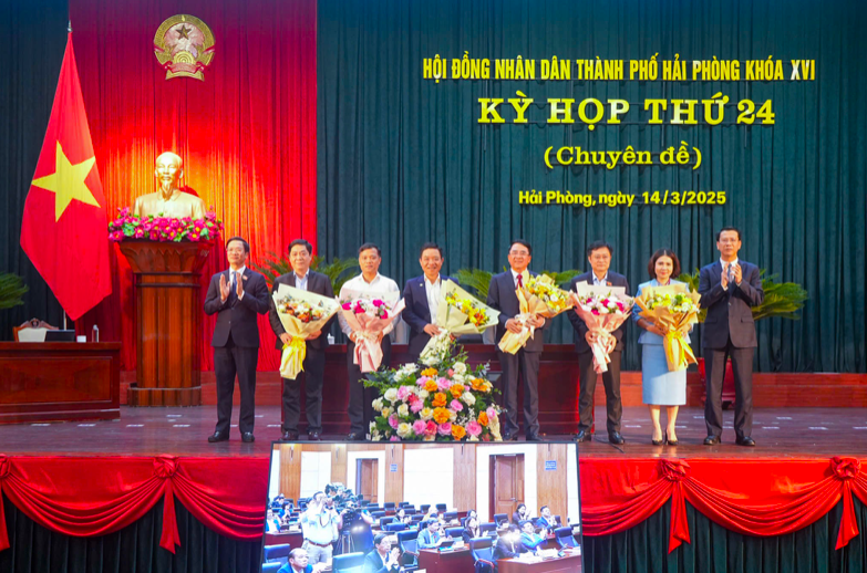 Chủ tịch HĐND thành phố Phạm Văn Lập tặng hoa cho các đại biểu được miễn nhiệm. Ảnh: CTT DT HP.
