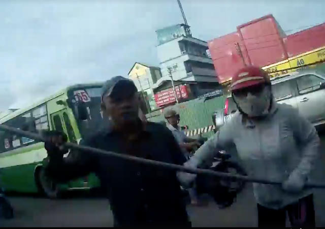 Có người còn cầm cả gậy dài đòi lao vào hành hung. Ảnh: Cắt từ clip.