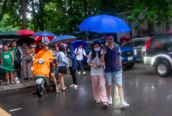 Nhiều bậc phụ huynh đội mưa đưa sĩ tử của mình đến điểm thi từ sáng sớm.