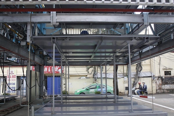 Giàn đỗ được trang bị hệ thống cảm biến thông minh nên khi hoạt động, nếu phát hiện có người hoặc vật thể ở gần lập tức có chuông cảnh báo và ngừng hoạt động giữ an toàn cho người vận hành cũng như phương tiện. Ảnh: Như Trường.