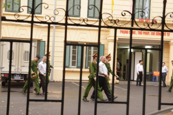 Các bị cáo được dẫn giải cáo vào phòng chờ, trong đó Nguyễn Xuân Sơn (người áo trắng, đi phía sau) đang mang bản án tử hình do liên quan đến một vụ án khác.