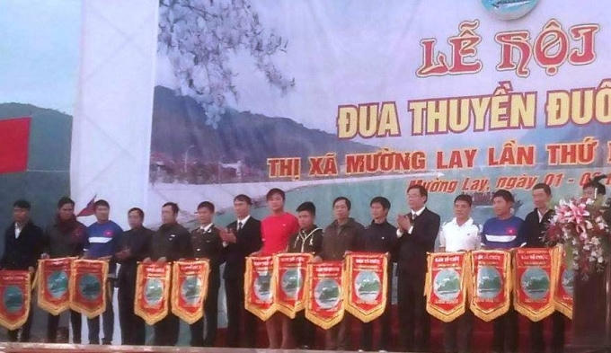Lãnh đạo Thị xã Mường Lay, Điện Biên tặng cờ lưu niệm cho trưởng đoàn các đội tham dự lễ hội đua thuyền.