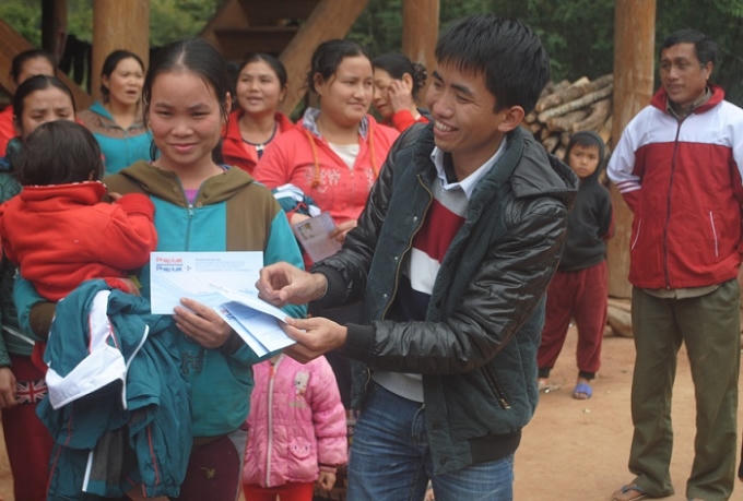 Phóng viên Báo Pháp luật Plus trao quà cho các gia đình ở bản Keng Đu (ảnh CTV).