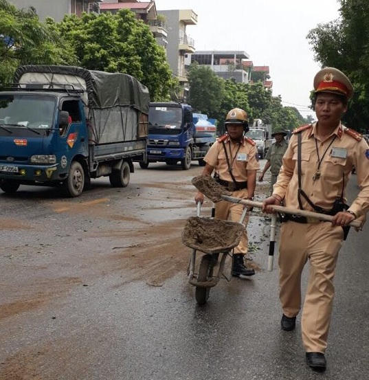Lực lượng CSGT có mặt tại hiện trường xử lý vết dầu do xe tải làm rơi.