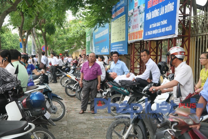  Thay vì gửi xe, rất nhiều phụ huynh sử dụng xe máy làm ghế ngồi, thậm chí có người còn tranh thủ ngả lưng trên yên xe để chờ đợi buổi thi kết thúc.