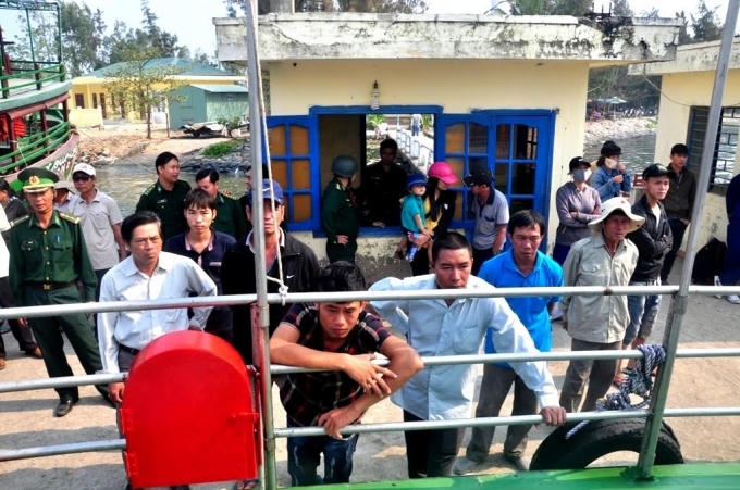 Người thân của tàu cá QNa 94592 chờ đón người thân trên cầu cảng Cửa Đại.