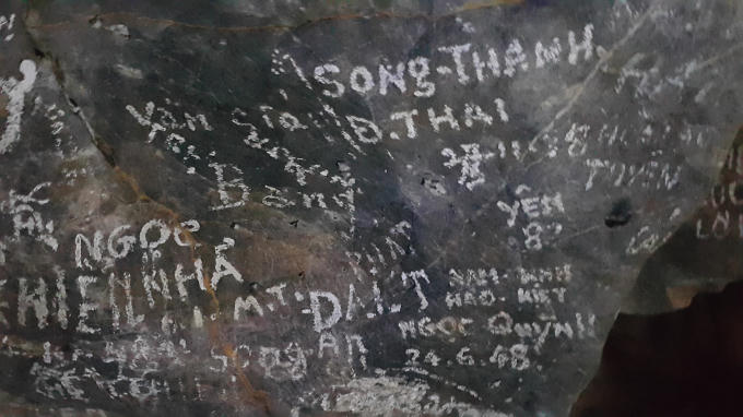 Những nét chữ nham nhở bằng bút xóa, sơn, phấn trắng viết tên người xuất hiện dày đặc ở các vách đá phẳng