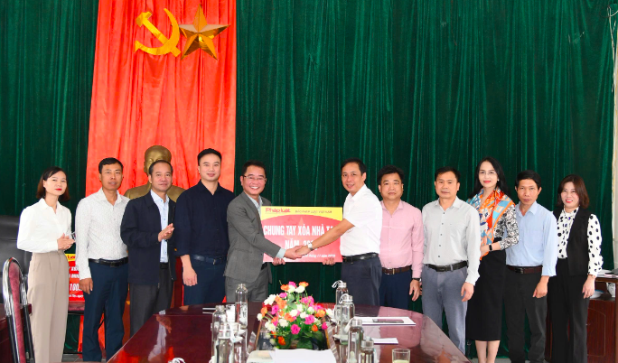 Tiến sĩ Vũ Hoài Nam - Bí thư Đảng Ủy, Tổng Biên tập trao hỗ trợ cho lãnh đạo địa phương.
